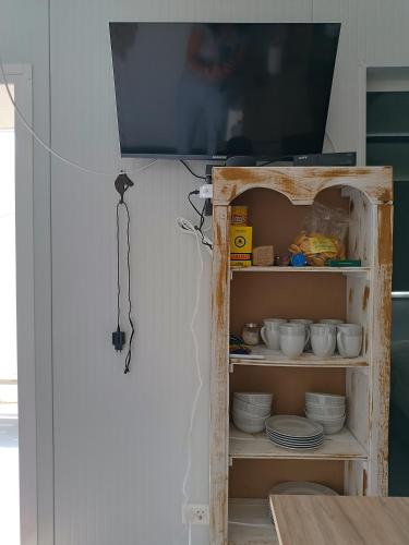 a tv sitting on top of a shelf with dishes at Casita de Piedra 12 y 13 in Trinidad