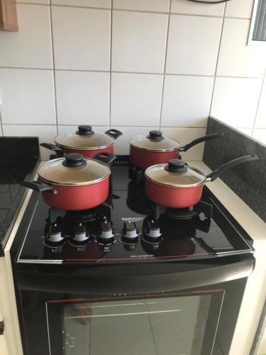 four pots on top of a stove in a kitchen at Ap. Espetacular. À 5 minutos da praia. in Aracaju