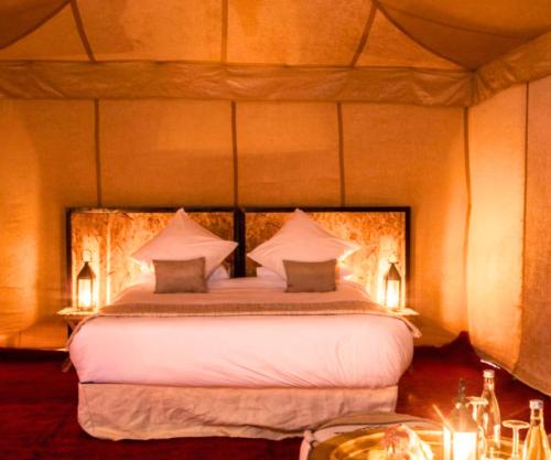 a bedroom with a large bed with two pillows at FABIN ATLAS MARRAKECH TOURS in Marrakech