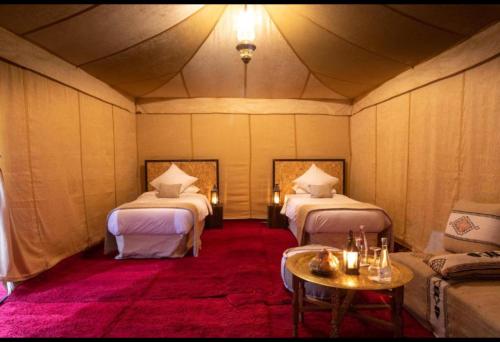 a room with two beds and a table at FABIN ATLAS MARRAKECH TOURS in Marrakech
