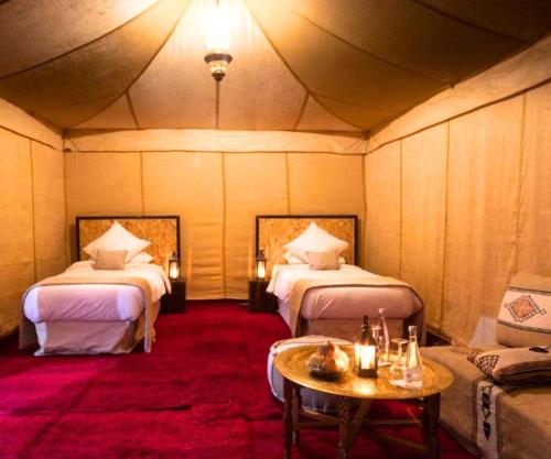a room with two beds and a table and a couch at FABIN ATLAS MARRAKECH TOURS in Marrakech