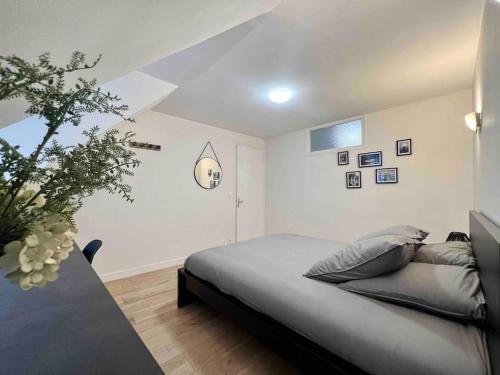 a bedroom with a bed and a vase of flowers at Appartement Centre-ville / 6 prsn / Bord du doubs / Au pied de la citadelle in Besançon