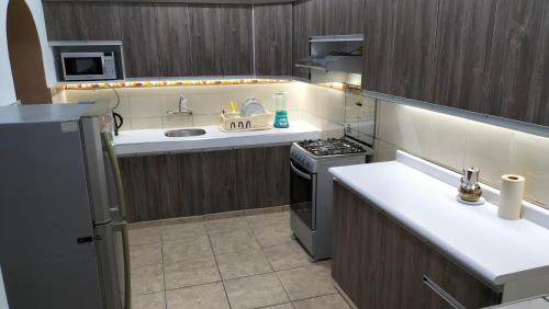 a kitchen with a sink and a stove at Hostel M Y M CENTRIC in Lima