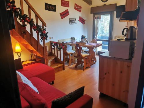 een woonkamer met een rode bank en een tafel bij Pichi's House in Cesuna