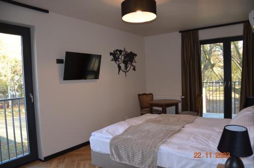a bedroom with a bed and a tv on the wall at Arte Gdańsk in Gdańsk