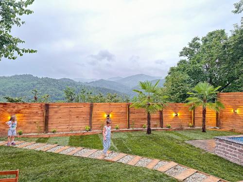 two children standing in a yard with a fence at Sapanca360bungalows in Sakarya