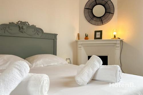 Schlafzimmer mit einem Bett mit weißen Kissen und einem Spiegel in der Unterkunft The House of Monthléry Comfort in Limoges in Limoges