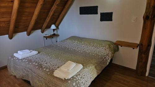 1 dormitorio con 1 cama con toallas en KILCA en Caviahue