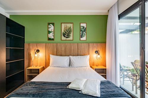 a bedroom with a bed and a green wall at Studios modernos e completos ao lado da estação Vila Mariana in Sao Paulo