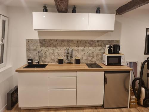 une cuisine avec des armoires blanches et un micro-ondes dans l'établissement Le panier Vieux-Port Marseille, à Marseille