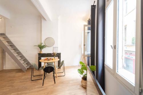 a small dining room with a table and a staircase at Studio Mezzanine Aumône Vieille in Aix-en-Provence