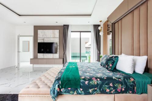 Astro Deluxe 4 Bedrooms Villa في Nong Prue: غرفة نوم بسرير كبير وتلفزيون