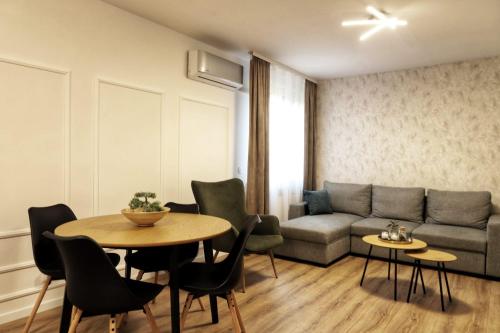 ein Wohnzimmer mit einem Sofa, einem Tisch und Stühlen in der Unterkunft Apartman Nila in Vukovar