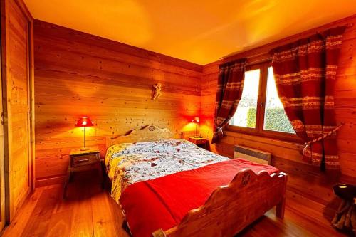 ein Schlafzimmer mit einem Bett in einem Holzzimmer in der Unterkunft Mignon Cocon avec terrasse face au Mont Blanc in Megève