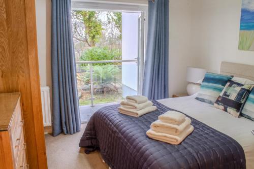 a bedroom with a bed with two towels on it at Sea Bleu in St Ives