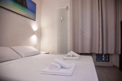 a bedroom with a white bed with towels on it at ROME Chic and Elegant Apartment near METRO Station in Rome