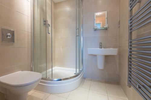 a bathroom with a shower and a toilet and a sink at Sea Bleu in St Ives