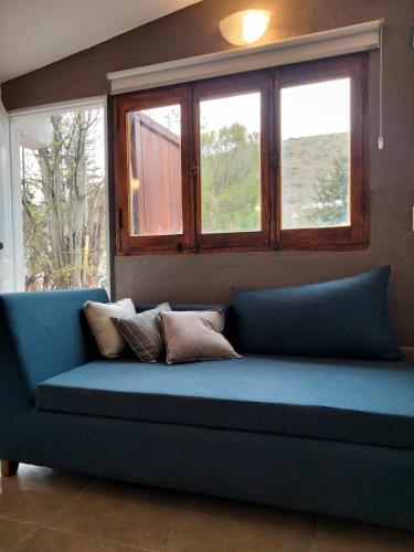 ポトレリージョスにあるLodge del Plataの窓2つ付きの客室で、青いソファが備わります。