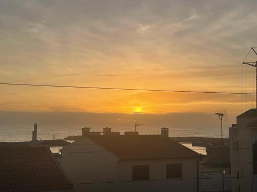 a sunset over the ocean with houses and buildings at BLUE ANCORA HOTEL in Vila Praia de Âncora