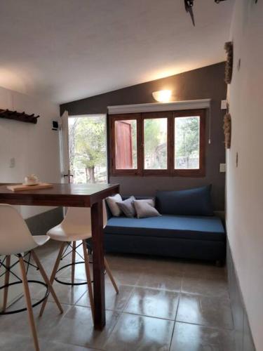 Lodge del Plata في بوتريريلوس: غرفة معيشة مع أريكة زرقاء وطاولة