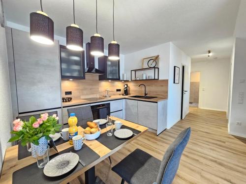 a kitchen and dining room with a table and chairs at FeWo Küstenquartier Dornumersiel in Dornum
