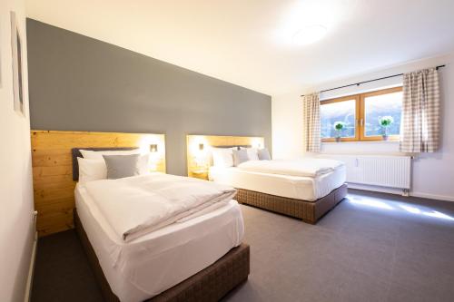 a bedroom with two beds and a window at Mittendrin in Garmisch-Partenkirchen