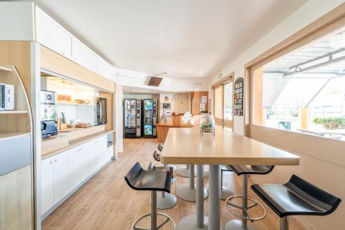 een keuken en eetkamer met een tafel en stoelen bij My KB Hôtel Montélimar in Saulce-sur-Rhône