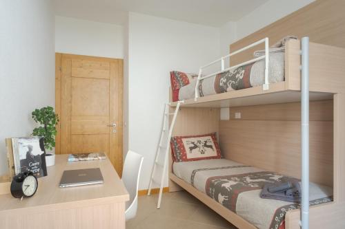 - une chambre avec des lits superposés et un bureau avec un ordinateur portable dans l'établissement Casa Bice, à Bormio