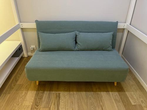 a blue couch in a room with wooden floors at Appartamento Isa in Tarvisio