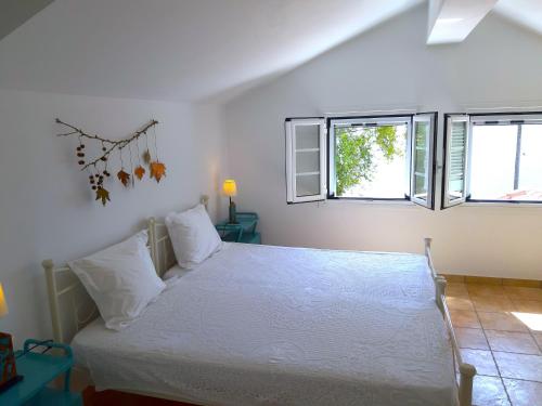 Karaḯskos的住宿－Beachfront Skaloma Villa，卧室配有白色床和2扇窗户