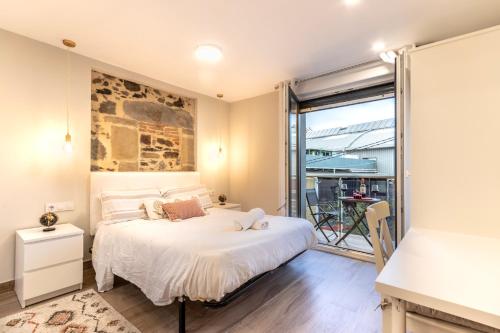 - une chambre avec un lit et un balcon dans l'établissement Apartamento El Toisón de Oro 22 Garaje gratis, à Bilbao