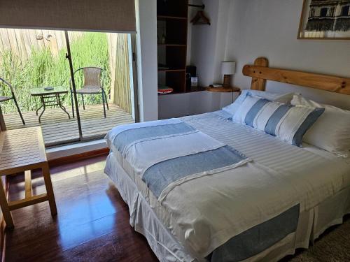 a bedroom with a bed and a balcony with a table at Casa Calfu in Santa Cruz