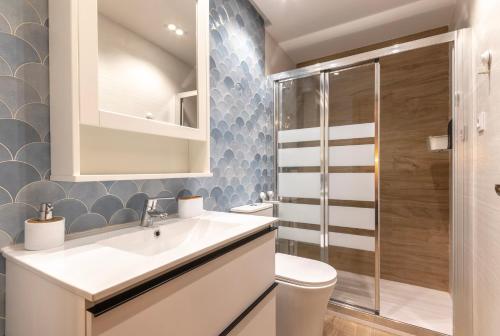 La salle de bains est pourvue de toilettes, d'un lavabo et d'une douche. dans l'établissement Apartamento El Toisón de Oro 22 Garaje gratis, à Bilbao