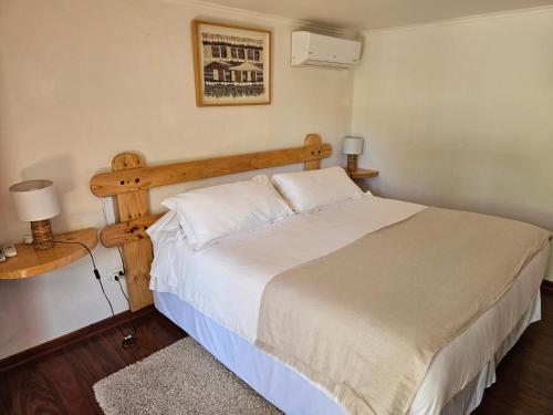 a bedroom with a large bed with a wooden headboard at Casa Calfu in Santa Cruz