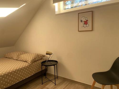a bedroom with a bed and a table with a lamp at Appartement dans une grange rénovée in Strasbourg