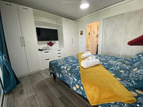 a bedroom with a bed with towels on it at le Kalinao, Anse des Rochers plage, piscine et cocotiers in Saint-François
