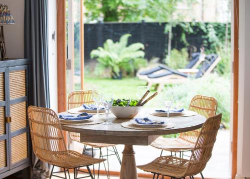 einen Tisch mit Stühlen und Weingläsern auf einer Veranda in der Unterkunft Crescent Lodge, Crouch End, London in London