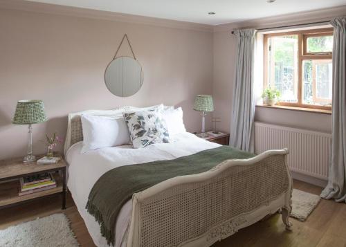 a bedroom with a large bed with white sheets and pillows at Crescent Lodge, Crouch End, London in London