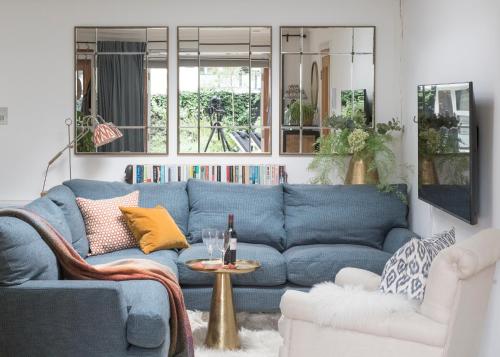 a living room with a blue couch and a table at Crescent Lodge, Crouch End, London in London
