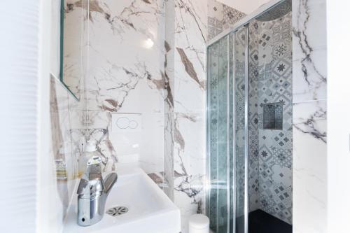 La salle de bains est pourvue d'un lavabo et d'une douche. dans l'établissement THE WHITE HOUSE BEAUSOLEIL- Monaco Border, à Beausoleil
