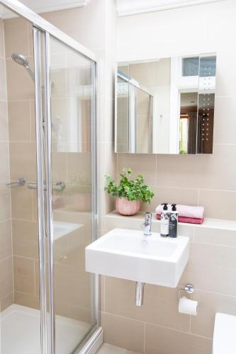a bathroom with a sink and a shower at Crescent Lodge, Crouch End, London in London