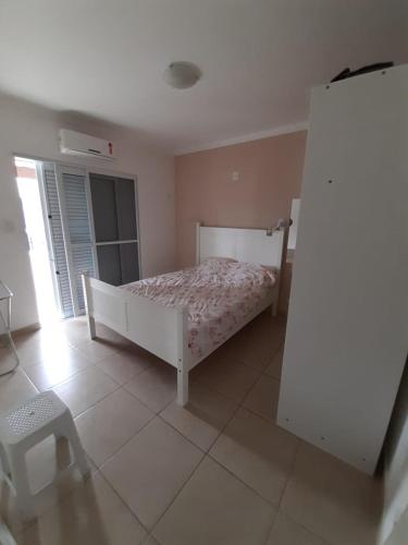 une chambre avec un lit dans une pièce avec une fenêtre dans l'établissement Casa Centro Caraguatatuba, à Caraguatatuba