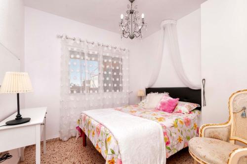 ビリャホヨサにあるPRIMERA LINEA, GRAN TERRAZA, MARAVILLOSAS VISTAS, ALTO standingの白いベッドルーム(ベッド1台、シャンデリア付)