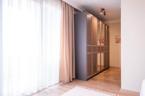 a dressing room with a closet and a large window at Gurel Garden House in Kucukkuyu