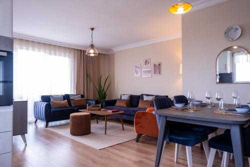 a living room with a blue couch and a table at Gurel Garden House in Kucukkuyu