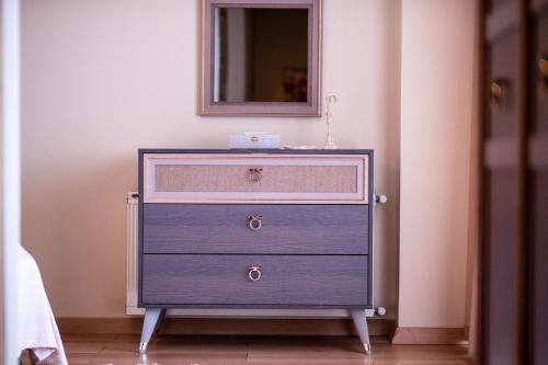 a blue dresser with a mirror on top of it at Gurel Garden House in Kucukkuyu