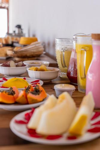een tafel met borden met eten en drinken bij Villa Alexandre Pousada - Trancoso in Trancoso