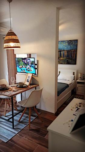 Bonaca Apartments في بودفا: غرفة مع مكتب وغرفة نوم مع سرير