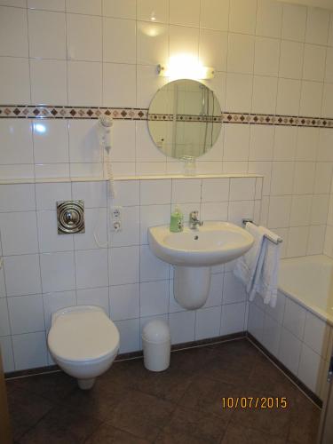 a bathroom with a sink and a toilet and a mirror at Kastanienhof in Mönchengladbach