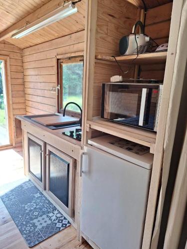 a kitchen in a tiny house with a stove at Le CHALET in Pressins